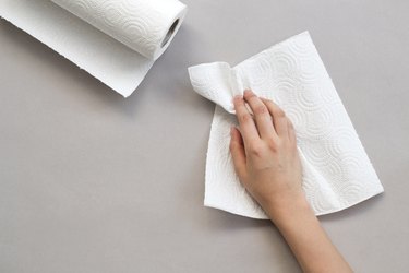 Woman wiping table with paper towel