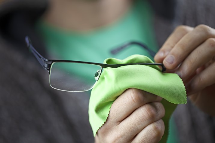 Midsection Of Man Cleaning Eyeglasses
