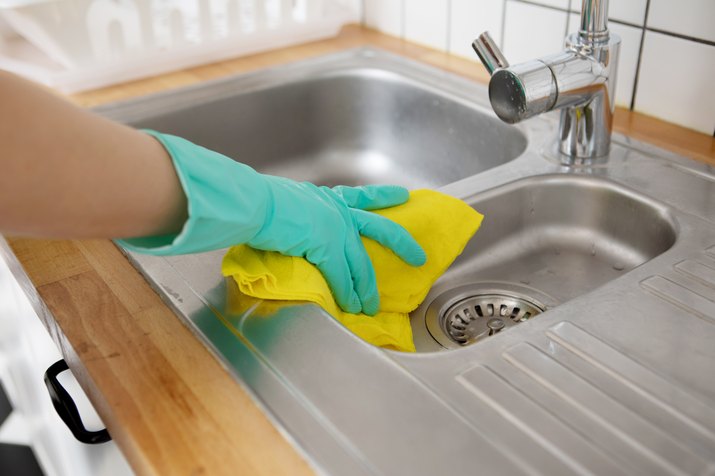 Close-Up Of Woman Hand Cleaning Kitchen Sink