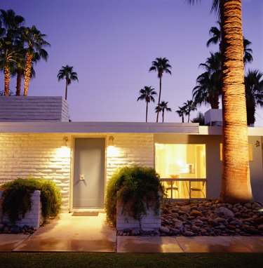 Exterior of brick home with palm trees in background