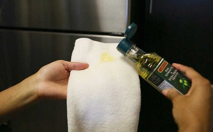 Olive oil applied to clean towel to polish stainless steel
