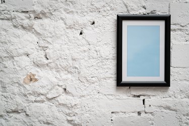 Blank frame on old white brick wall