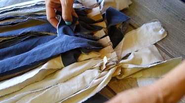 Weaving rag rug using a cardboard loom and fabric scraps.
