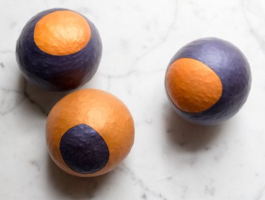 Three purple and gold homemade stress balls