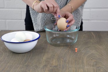 Using straightened paperclip to mix egg white and yolk.