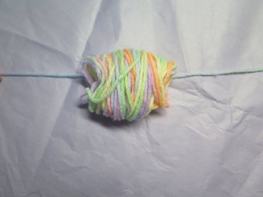 Lay the yarn strand underneath the bundle.