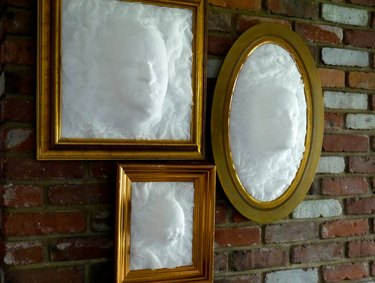 3 separate picture frames each with a cheesecloth ghost head